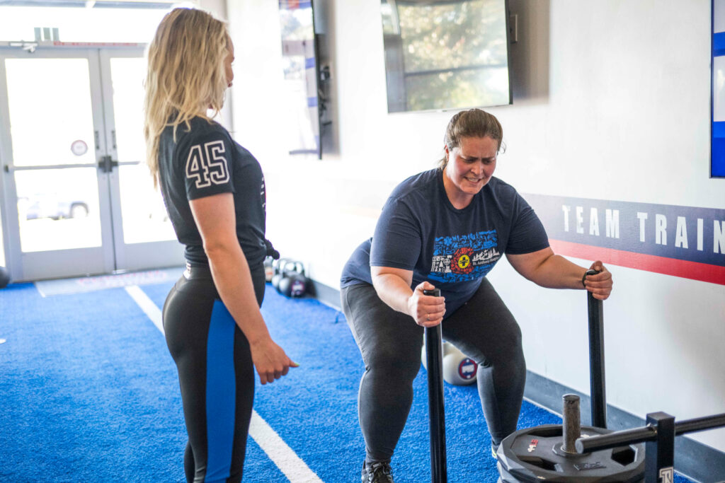 Personal trainer assisting a member during a workout session at F45 studio in Ventura County