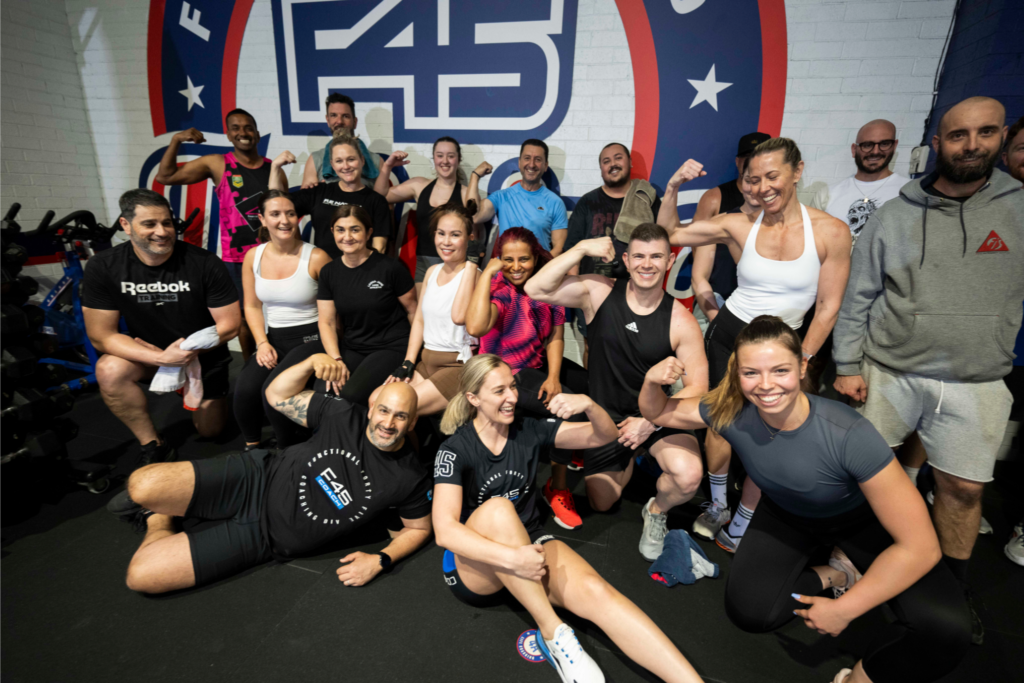 Small gyms around me community members cheering each other on during a workout session